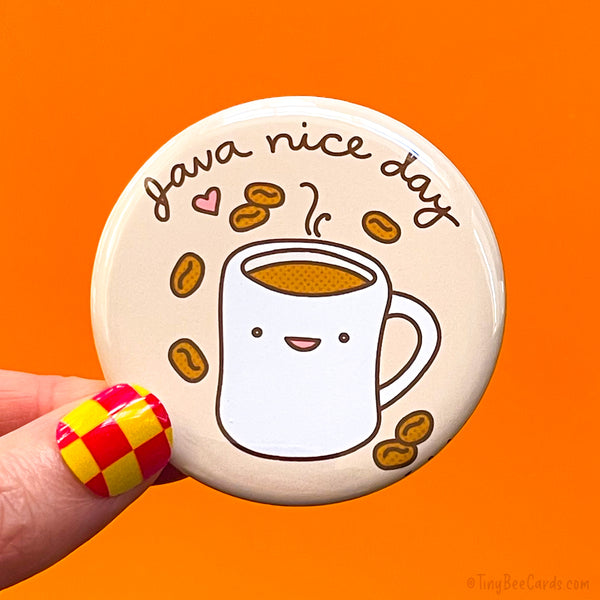 Button badge with hand drawn artwork of a coffee mug with a happy face and 'Java nice day' text on a brown background