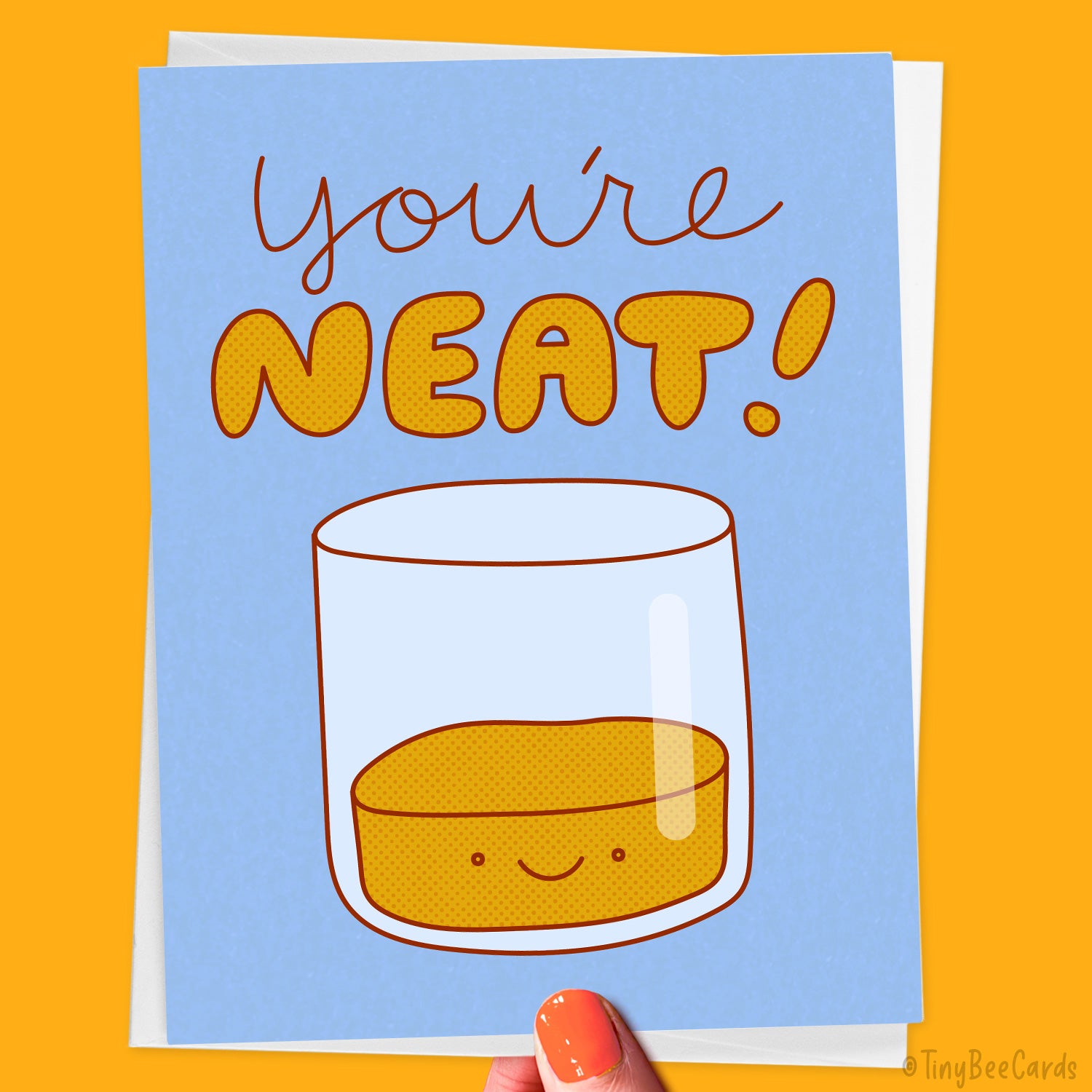 Greeting card with a glass of alcohol and 'You're NEAT!' text on a blue background, held against an orange background.