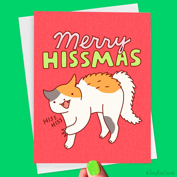 A hand drawn greeting card with an illustration of a fluffy calico cat hissing, and the text "Merry HIssmas."