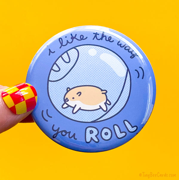 Button badge with a hand drawn hamster and text 'I like the way you roll' 