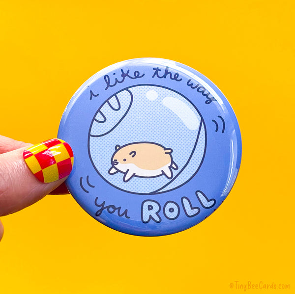 Button badge with a hand drawn hamster and text 'I like the way you roll' 